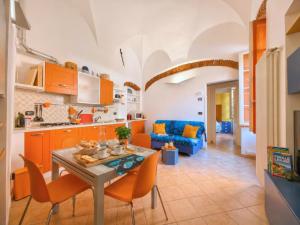 a kitchen and living room with a table and chairs at Rivierarent Casa Nemo in Finale Ligure
