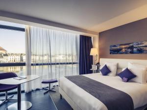 a hotel room with a bed and a large window at Mercure Cherbourg Centre Port in Cherbourg en Cotentin +94 photos
