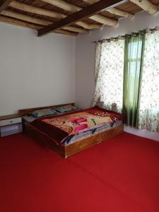a bedroom with a bed and a red carpet at White rose homestay in Kaza