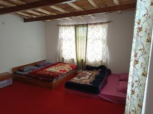 two twin beds in a room with curtains at White rose homestay in Kaza