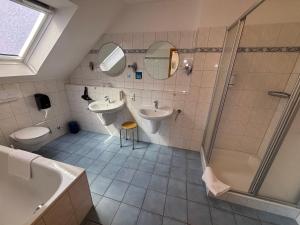 a bathroom with two sinks and a shower at Hotel Friesenhof in Westoverledingen +69 photos