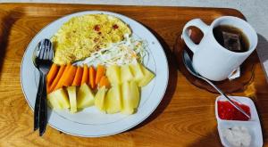 a plate of food with carrots and rice on a table at Kurniawan Homestay in Pulau Sarang +12 photos