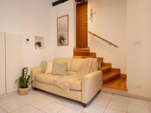 a living room with a couch and a staircase at Nel centro storico di Ovada in Ovada +5 photos