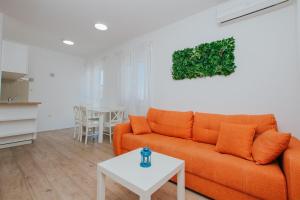 a living room with an orange couch and a table at Villa Iva-Dom in Kaštela +148 photos