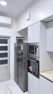 a kitchen with a refrigerator and a microwave at Villa Al Khair in Medina