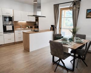 a kitchen with a table and chairs and a kitchen with a counter at Boutique Appartements Kumming inkl Nationalparkcard in Rauris
