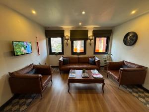 a living room with leather couches and a coffee table at NENEHATUN59 BUTİK OTEL in Ankara