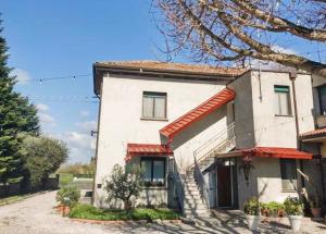 a white house with a red awning on it at Agli Ulivi in Filo