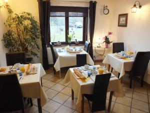 a restaurant with tables and chairs with food on them at La Jolimessine in Jolimetz
