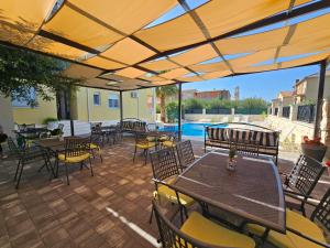 a patio with tables and chairs and a pool at Villa Iva-Dom in Kaštela