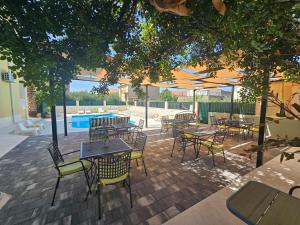 an outdoor patio with tables and chairs and a pool at Villa Iva-Dom in Kaštela