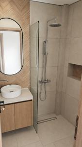 a bathroom with a shower and a sink at Elina's Era Lounge Apartment in Palekastron +15 photos