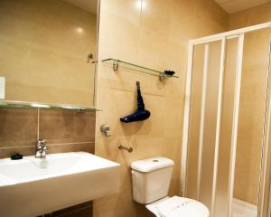 a bathroom with a toilet and a sink and a shower at Plaza de la Luz Cádiz in Cádiz