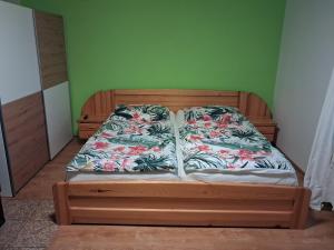 a bed in a room with a green wall at Žamberk-apartmán líšnice in Žamberk