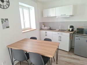 a kitchen with a wooden table and chairs at L'ESPOIRENTHESE T2 35m2 in Nieuil-lʼEspoir