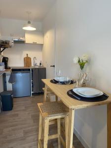 a kitchen with a wooden table with a plate on it at Charmant Studio in Le Teich