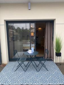a patio with a table and chairs on a floor at Charmant Studio in Le Teich