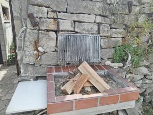 a brick fire pit in front of a stone wall at Beach Island House in Korčula