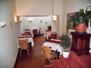 un comedor con mesas, sillas y una planta en Hotel Freihof en Wiesloch