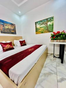 a bedroom with a large bed with red pillows at Akrafthaus by KAVKANZ in Abuja +26 photos