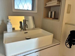 a white sink in a bathroom with a mirror at Recasa in Imabari +33 photos
