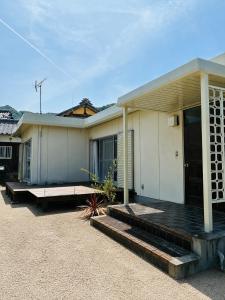 a white house with a porch and a driveway at Recasa in Imabari