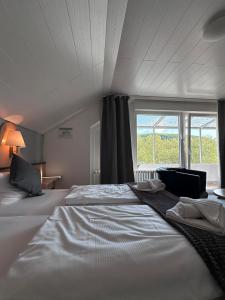 ein großes Bett in einem Zimmer mit einem großen Fenster in der Unterkunft Hotel Bevertal in Beverungen