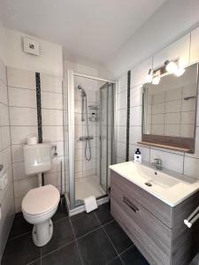 ein Badezimmer mit Toilette, Dusche und Waschbecken in der Unterkunft Hotel Bevertal in Beverungen + 65 Fotos