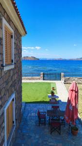 a patio with a table and chairs and the ocean at Aura Seaside Apartments in Petra