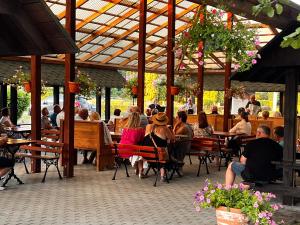 a group of people sitting at tables in a restaurant at Pokamedulski Klasztor w Wigrach in Wigry
