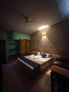 a bedroom with a bed and a light on the wall at Hotel Gangotri in Bahāsi