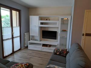 a living room with a couch and a tv at CASA VACANZE FRANCIACORTA in Colombaro