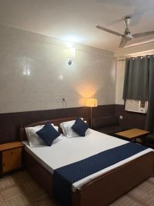 a bedroom with a large bed with blue pillows at Hotel Gangotri in Bahāsi