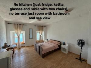 a bedroom with a bed and a desk with a fan at Studio apartman i sobe SIDRO in Karlobag