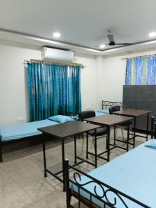 a classroom with tables and chairs in a room at Nasa Hostel in Panchanai