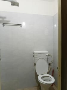 a bathroom with a white toilet in a stall at Nasa Hostel in Panchanai