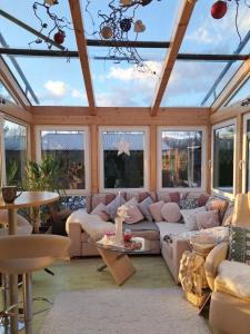 a conservatory with a couch and tables and windows at Beates Daham in Fohnsdorf