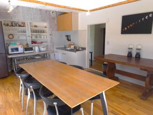 a kitchen with a wooden table and some chairs at Natuur one Kamogawa in Minamiboso
