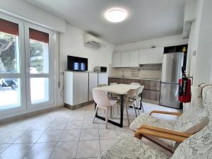 a kitchen with a table and chairs in a room at Attico Resplendor Fronte mare in Rosolina Mare