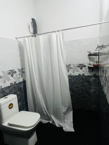 a bathroom with a toilet and a shower curtain at Cactus Piliyandala in Piliyandala +38 photos