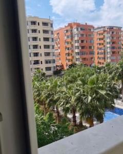 a view of palm trees and buildings from a balcony at Shengjin City Apartment 1 in Skataj