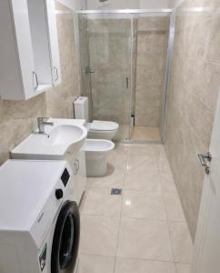 a bathroom with a toilet and a sink and a shower at Shengjin City Apartment 1 in Skataj