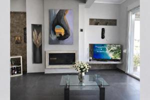 a living room with a fireplace and a vase of flowers at Sunrise Villa in Kassandra
