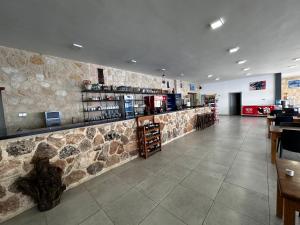 a bar in a restaurant with a stone wall at Golden Hill Hotel in Rizokarpaso