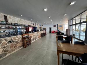a restaurant with tables and chairs and a stone wall at Golden Hill Hotel in Rizokarpaso +68 photos
