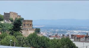 a large building on top of a hill with trees at Appartement Royat 2 pers Romeuf in Royat