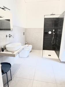 a bathroom with a toilet and a sink and a shower at Hercules Suites in Noto +39 photos