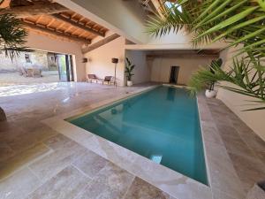 a swimming pool in a house with a patio at Bastide Hedone en Luberon in Apt