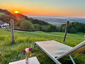 a bed in a field with the sunset in the background at Siglhof am Pattenberg in Bergen +7 photos