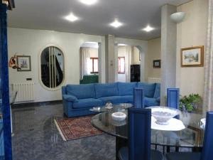 a living room with a blue couch and a glass table at Villa Ara Dell'Etna in Pedara